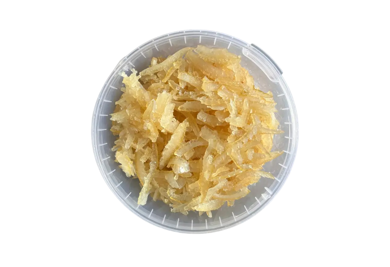 Coajă de lămâie confiată răzuită într-o cantitate de 700 de grame fotografiată de sus într-un recipient transparent din plastic