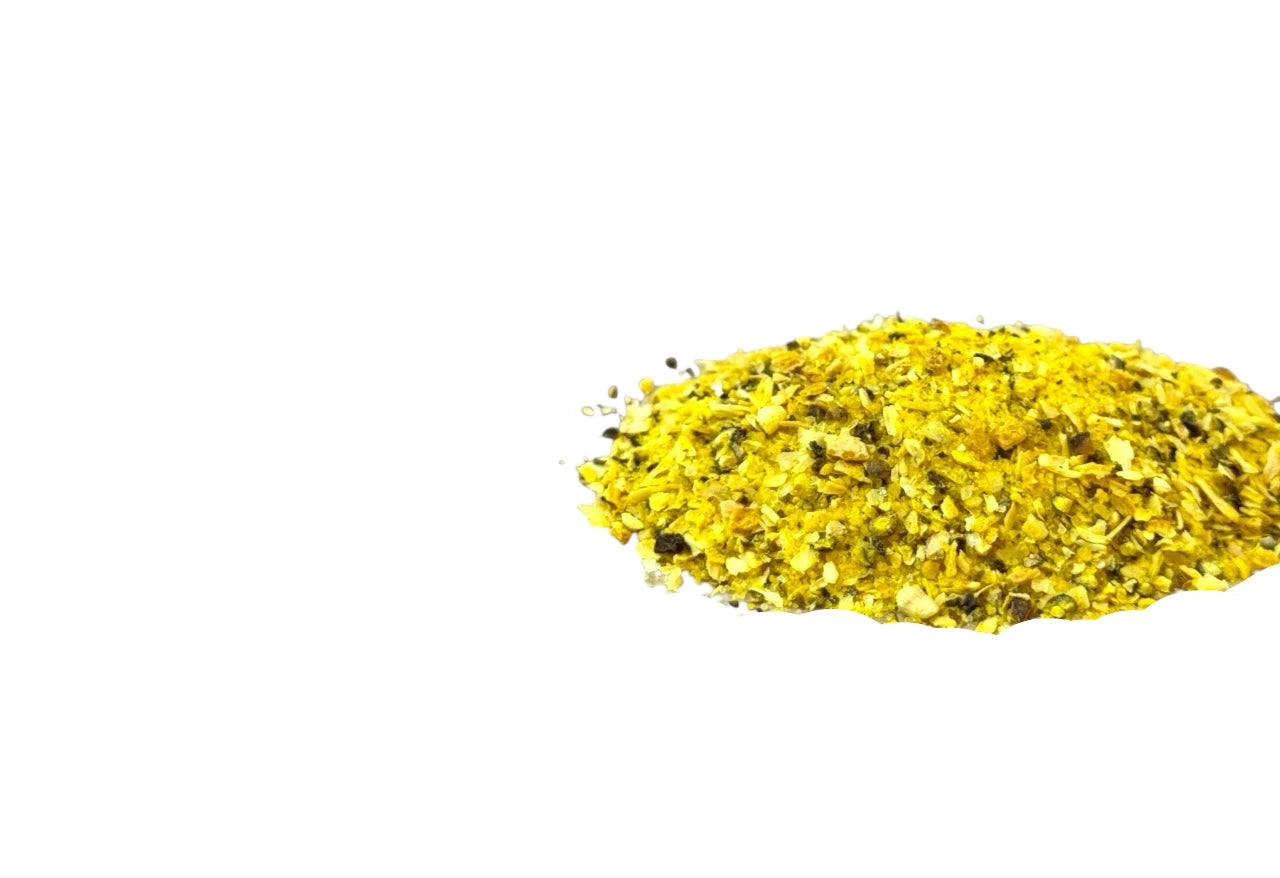 Amestec de piper cu lămâie, cu granule galbene și verzi, vărsat pe fundal alb. Condiment cu aromă intensă, ușor citrică.